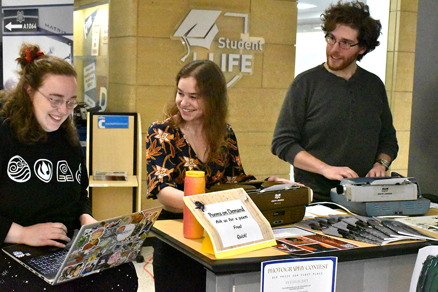 Members of the Yahara Journal staff promote an event by offering poetry on demand at a table at the Truax Campus.