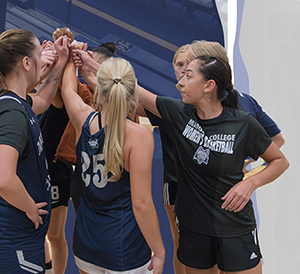 Members of the Madison College womens basketball team meet during a break in play.