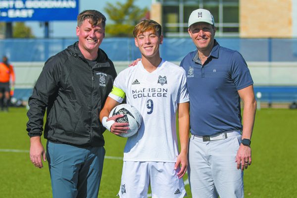 Coach Logan Fye, left, and Athletic Director Jason Verhelst, right, recognize Gabe Voung for his record-setting efforts prior to the team’s final match.  