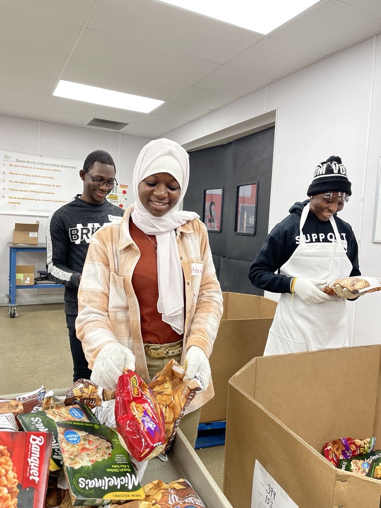 Assane Ouedraogo, Hawa Nayaga and Josephine Segrado (from left to right) sorted meats, pizza, ice cream and other frozen meals at Second Harvest. Photo provided by Volunteer Center.