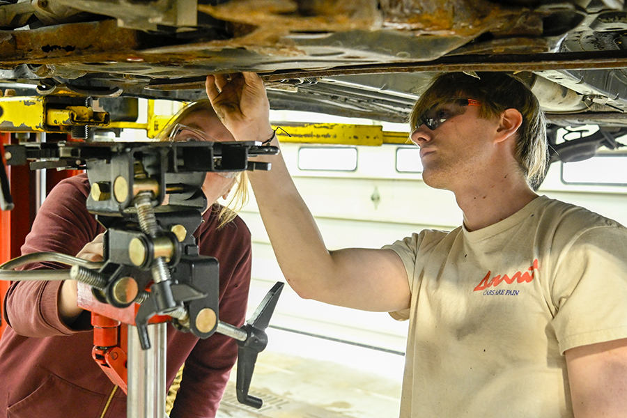 Logan Bossinger (left) and Nathan Komplin (right) work on a car during their class in the Auto Tech Program. 