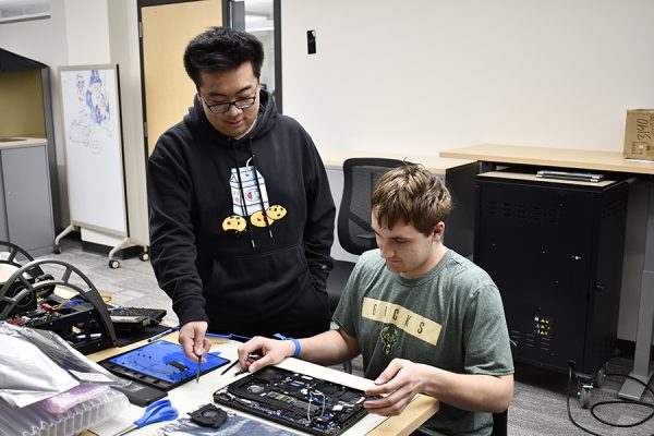 WolfPack Techies student volunteers Chee Yeng Thao, left, and Logan Reich work on a laptop circuit board.