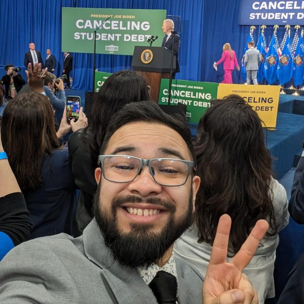 Kai Brito takes a selfie with United States President Joe Biden in the background. 