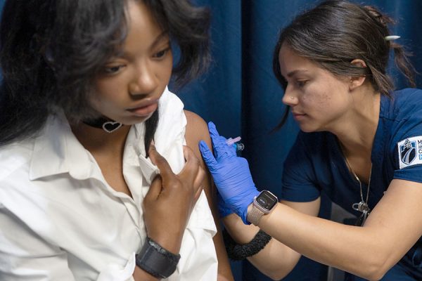 Photo of Madison College student Kylie Phillips, left, getting a flu shot on campus earlier this semester.