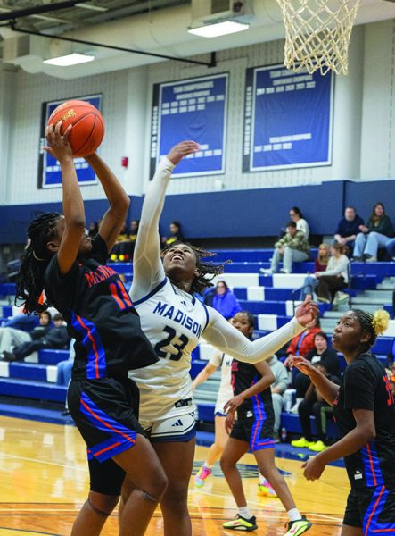 Photo of women's basketball player trying to block a shot.