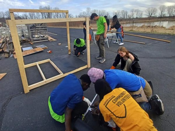 Photo of students helping to build a wooden frame.
