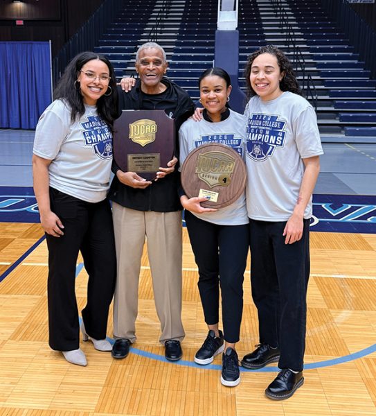 Photo of four coaches holding trophies.
