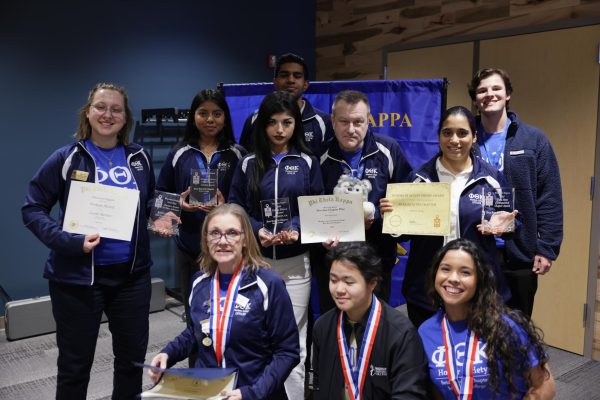 A group of Phi Theta Kappa members show their award certificates.