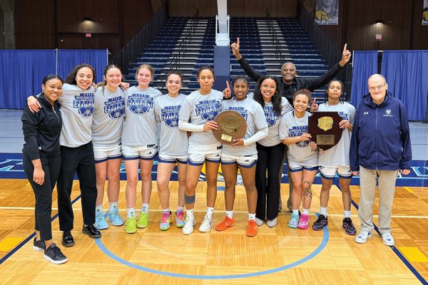 Group photo of a women's basketball team with trophies.