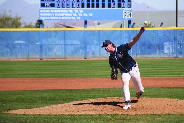 A baseball pitcher releases the ball toward home plate.
