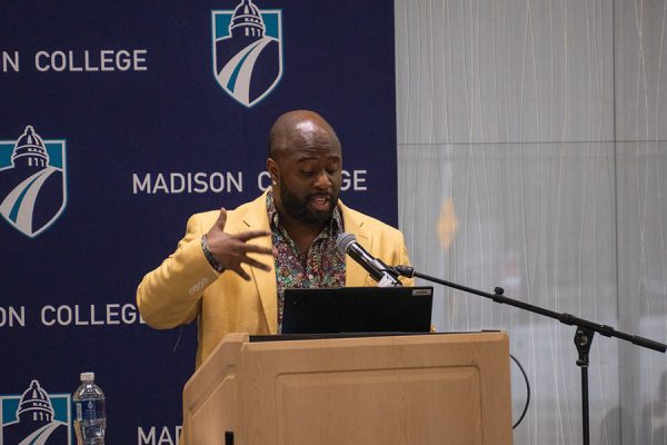 A man gestures as he speaks from a podium.
