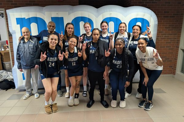 The Madison College women's basketball team poses together outside the basketball arena.